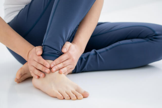 足首を両手で触る人